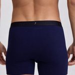 Navy blue boxer briefs worn by a person on a light gray background