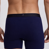 Navy blue boxer briefs worn by a person on a light gray background