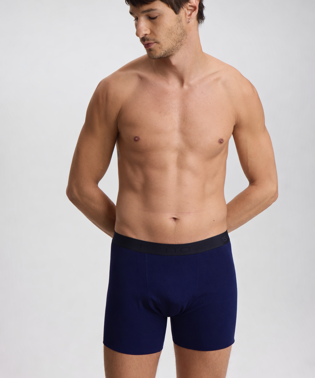 Man wearing navy blue boxer briefs on a white background