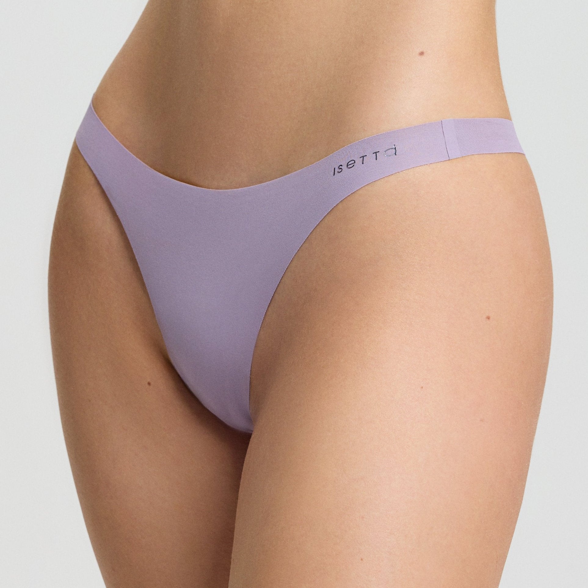 Person wearing a light purple bra and underwear set on a plain background