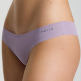 Purple underwear worn by a person on a light gray background