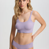 Woman wearing a lavender sports bra and underwear set on a light gray background