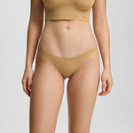 Person wearing a beige bikini set on a plain background