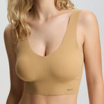 Woman wearing a beige bra and panties set on a white background