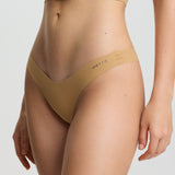 Person wearing a beige bikini set on a white background