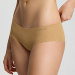 Person wearing beige high-waisted underwear with brand logo on a light gray background
