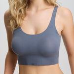 Woman wearing a gray sports bra against a plain background