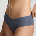 Person wearing a gray sports bra and underwear set on a light gray background