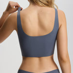 Person wearing a gray sports bra and underwear set on a plain background