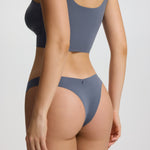 Person wearing a gray bikini set on a plain background