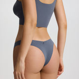 Person wearing a gray bikini set on a plain background