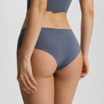 Person wearing a gray sports bra and high-waisted underwear set on a plain background