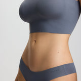 Person wearing a gray sports bra and underwear set on a plain background
