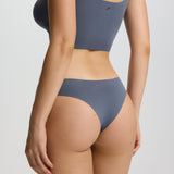 Person wearing a gray bikini set on a plain background